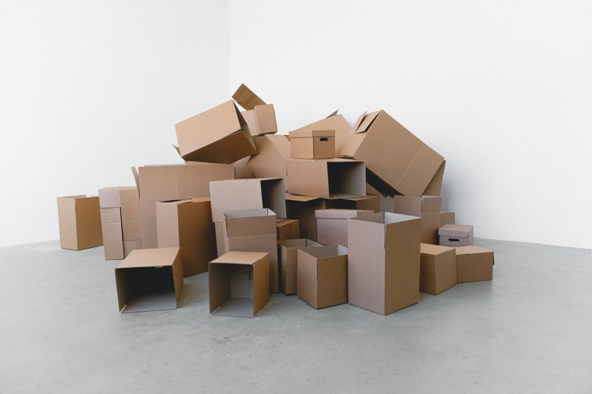 Une pile de cartons d'emballage marron de tailles différentes accumulés dans une pièce vide pour illustrer comment et où récupérer des cartons de déménagement gratuits près de chez moi.
